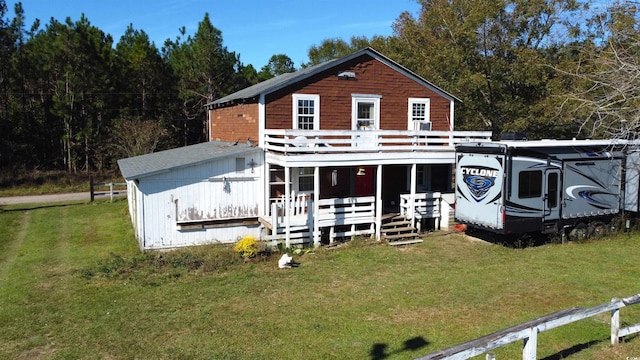 rear view of property featuring a porch and a yard