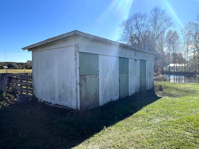 view of outbuilding featuring a water view and a yard