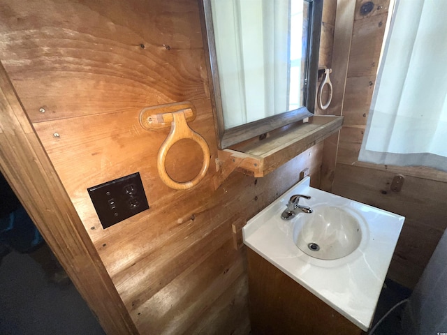 bathroom with vanity and wooden walls