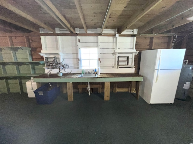 basement featuring sink and white fridge