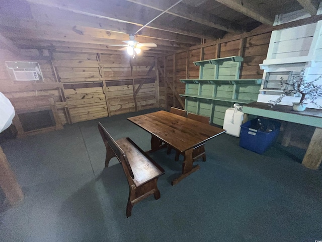 basement featuring wooden walls and ceiling fan