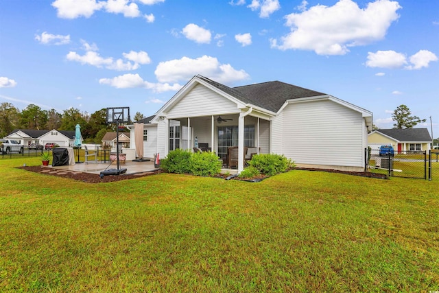 back of property featuring a lawn, a patio area, a sunroom, and ceiling fan