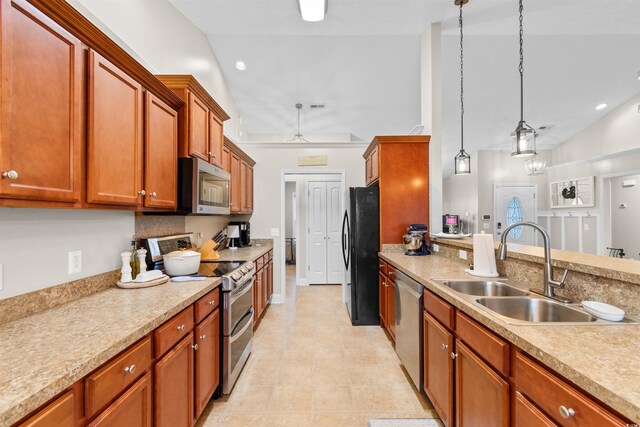 kitchen with sink, high vaulted ceiling, light tile patterned floors, decorative light fixtures, and stainless steel appliances