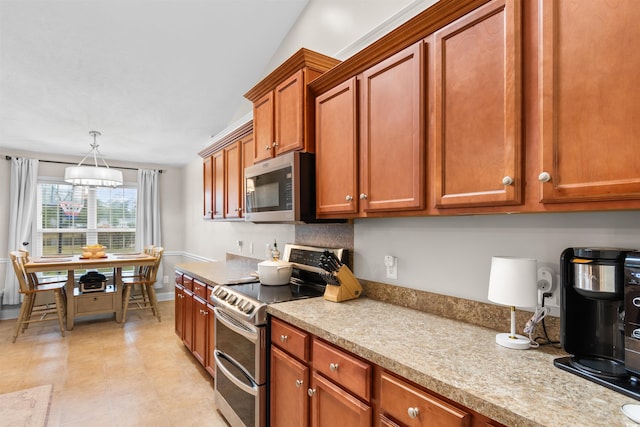 kitchen with appliances with stainless steel finishes and pendant lighting