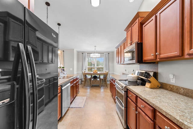 kitchen featuring a chandelier, sink, pendant lighting, and appliances with stainless steel finishes