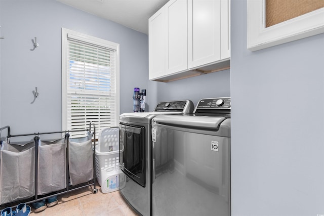 laundry room featuring washer and clothes dryer, light tile patterned flooring, and cabinets