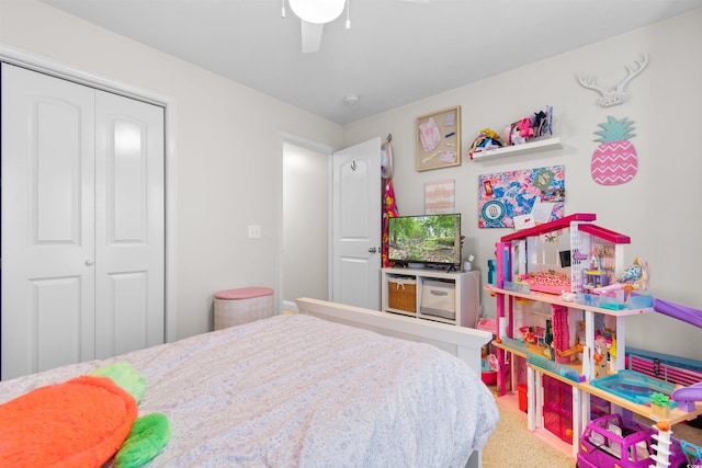 carpeted bedroom with ceiling fan and a closet