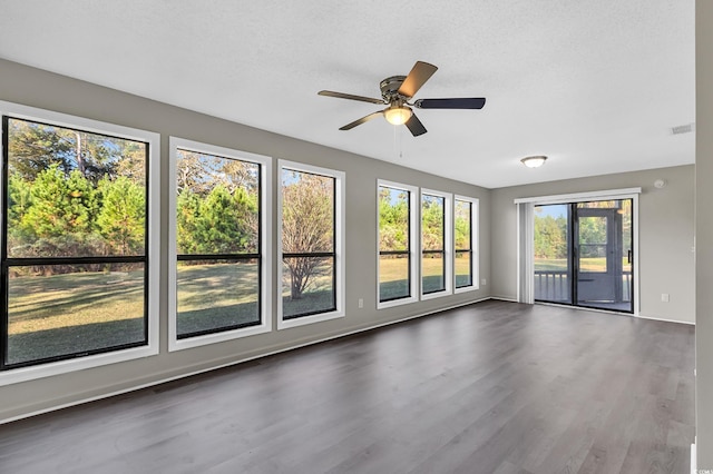 unfurnished room featuring a textured ceiling, dark hardwood / wood-style floors, and ceiling fan