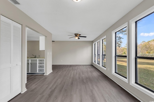 interior space with ceiling fan, sink, and a wealth of natural light