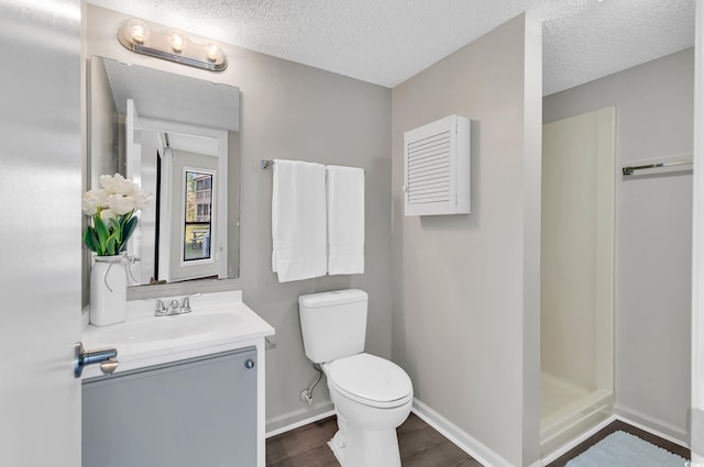 bathroom featuring a shower, wood-type flooring, a textured ceiling, toilet, and vanity