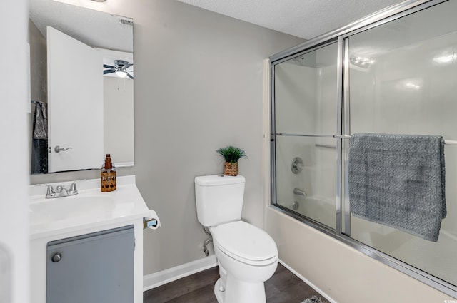 full bathroom featuring combined bath / shower with glass door, ceiling fan, toilet, a textured ceiling, and wood-type flooring