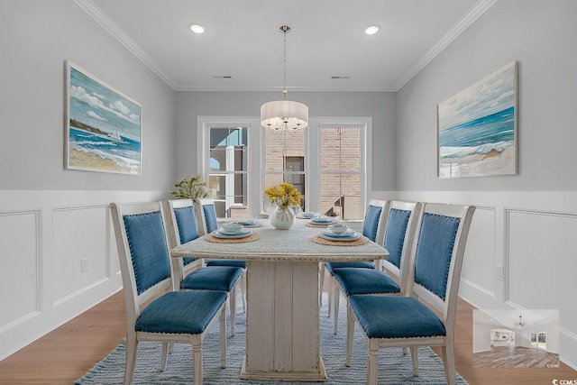 dining area featuring hardwood / wood-style floors, a chandelier, and ornamental molding