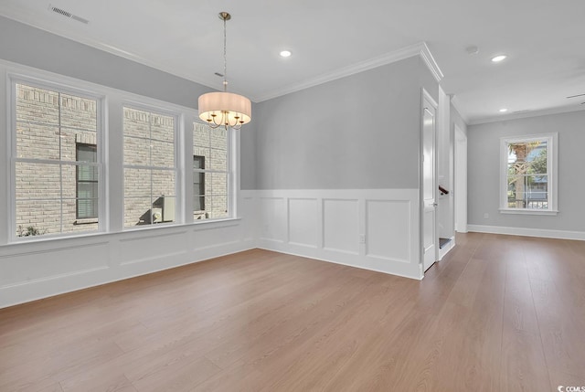 unfurnished room with an inviting chandelier, light hardwood / wood-style floors, and ornamental molding