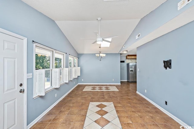 interior space featuring ceiling fan and vaulted ceiling with skylight