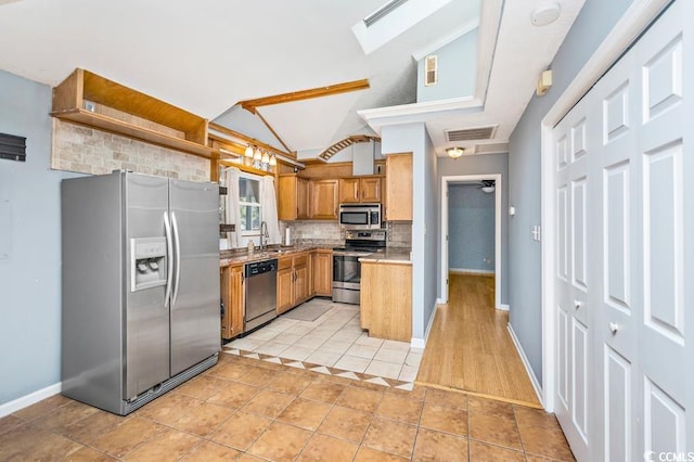 kitchen featuring ceiling fan, sink, lofted ceiling, light tile patterned floors, and appliances with stainless steel finishes