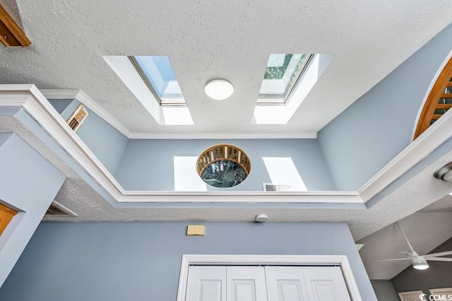 details featuring ceiling fan, a textured ceiling, and ornamental molding