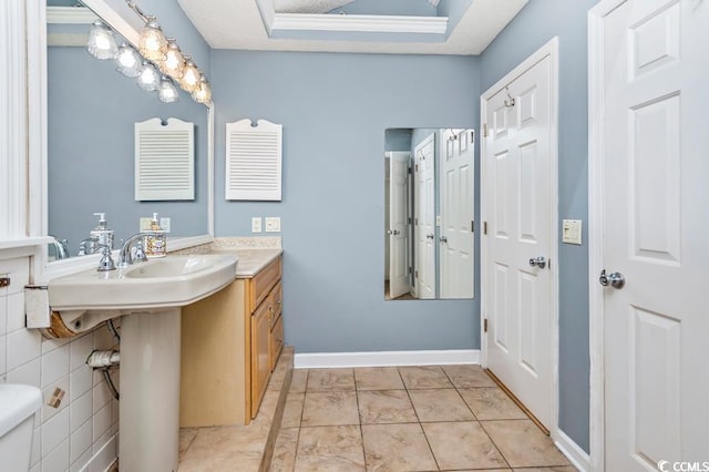 bathroom with tile patterned flooring, a tray ceiling, toilet, and ornamental molding