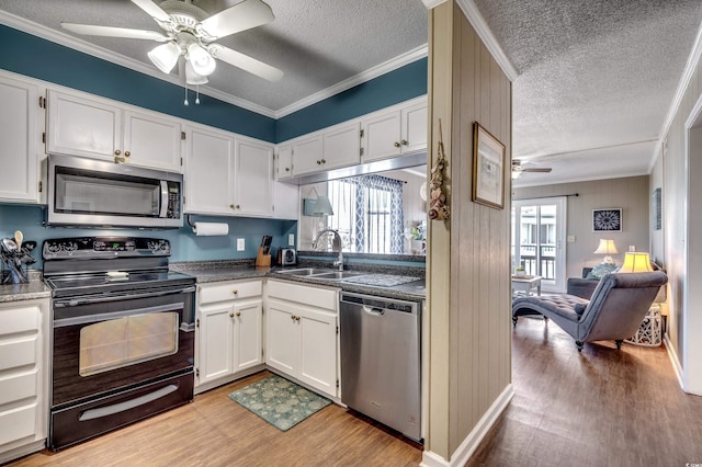 814 N Waccamaw Dr Unit 311, Garden City Beach, SC 29576 - kitchen with appliances with stainless steel finishes, a ceiling fan, light wood finished floors, a textured ceiling, and white cabinetry
