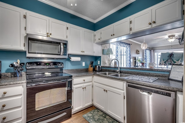 814 N Waccamaw Dr Unit 311, Garden City Beach, SC 29576 - kitchen with appliances with stainless steel finishes, ceiling fan, white cabinets, light wood finished floors, and ornamental molding