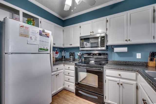 814 N Waccamaw Dr Unit 311, Garden City Beach, SC 29576 - kitchen featuring freestanding refrigerator, stainless steel microwave, black / electric stove, white cabinets, and dark countertops