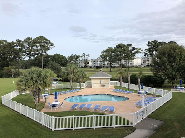 view of swimming pool with an outdoor structure, a patio, and a lawn