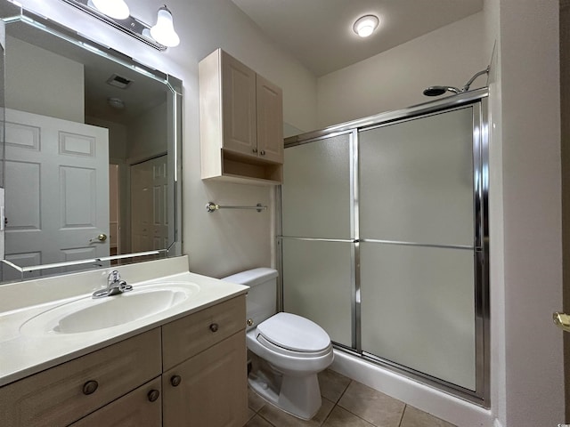 bathroom featuring vanity, toilet, a shower with shower door, and tile patterned flooring