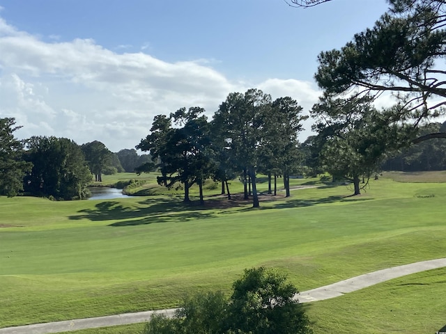 surrounding community featuring a water view and a lawn