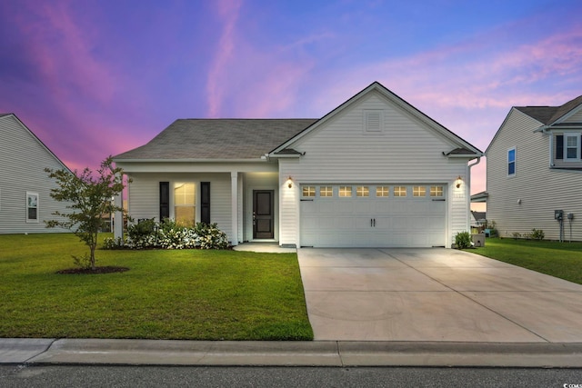 view of front of home with a garage and a yard