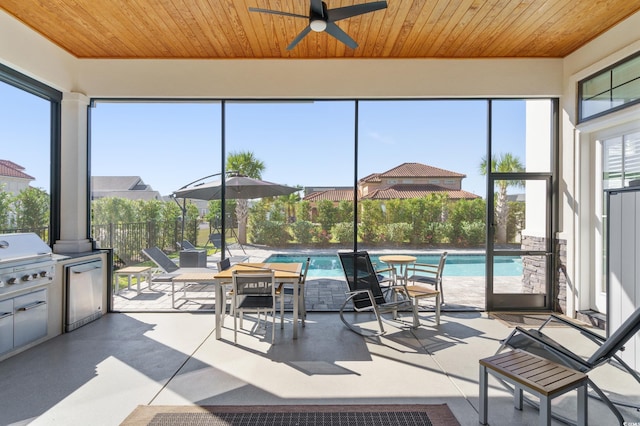 sunroom featuring ceiling fan and wooden ceiling