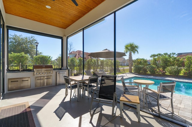 sunroom featuring ceiling fan and wooden ceiling