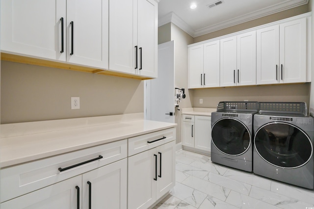 washroom with cabinets, crown molding, and washing machine and clothes dryer