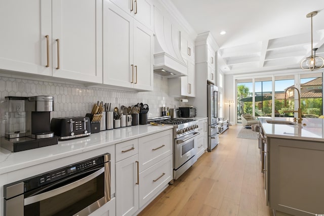 kitchen featuring decorative backsplash, light hardwood / wood-style flooring, white cabinets, and appliances with stainless steel finishes