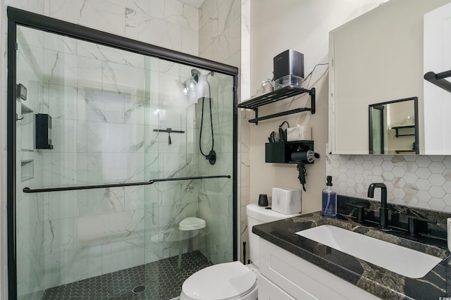 bathroom with decorative backsplash, toilet, a shower with door, and vanity