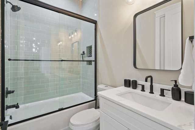 full bathroom featuring vanity, toilet, and bath / shower combo with glass door