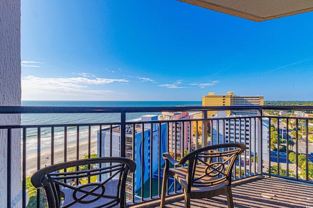 balcony featuring a water view and a beach view