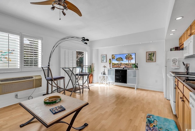 living room with ceiling fan, light hardwood / wood-style floors, and an AC wall unit