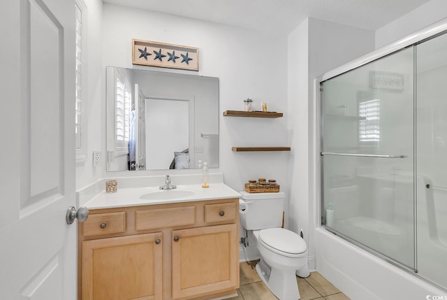 full bathroom with tile patterned floors, bath / shower combo with glass door, a textured ceiling, toilet, and vanity