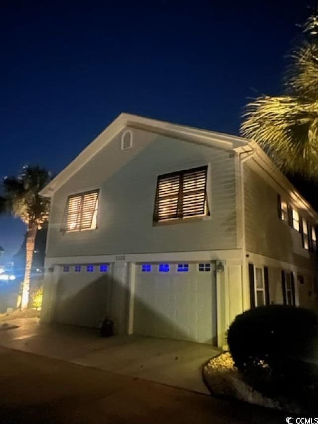 property exterior at night featuring a garage