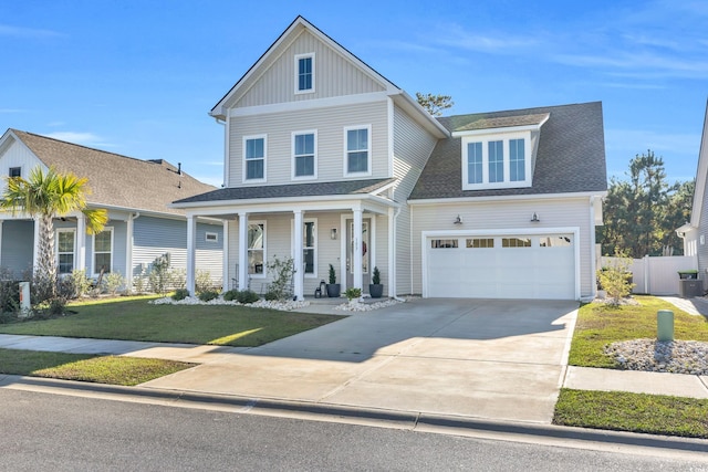 view of front of house featuring a porch, a garage, and a front lawn