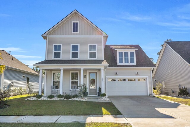 view of front of home with covered porch, a front yard, and a garage