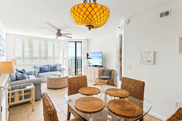 living room featuring expansive windows, ornamental molding, a textured ceiling, ceiling fan, and light tile patterned floors