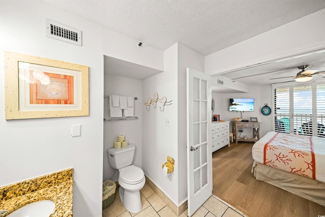 bedroom featuring ceiling fan, light wood-type flooring, and a textured ceiling