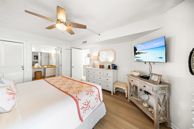 bedroom with ceiling fan, light hardwood / wood-style floors, and connected bathroom