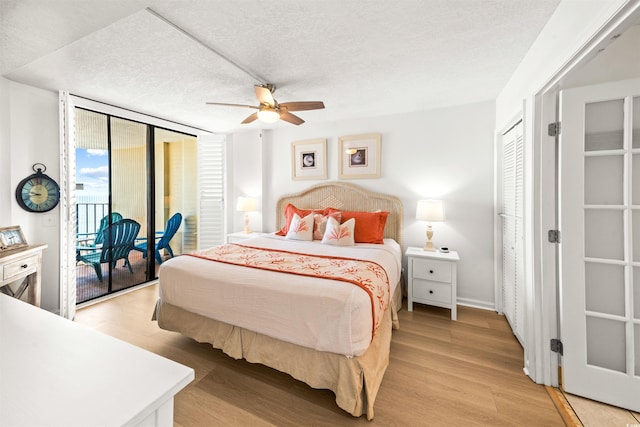 bedroom featuring ceiling fan, light hardwood / wood-style floors, a textured ceiling, access to outside, and a closet