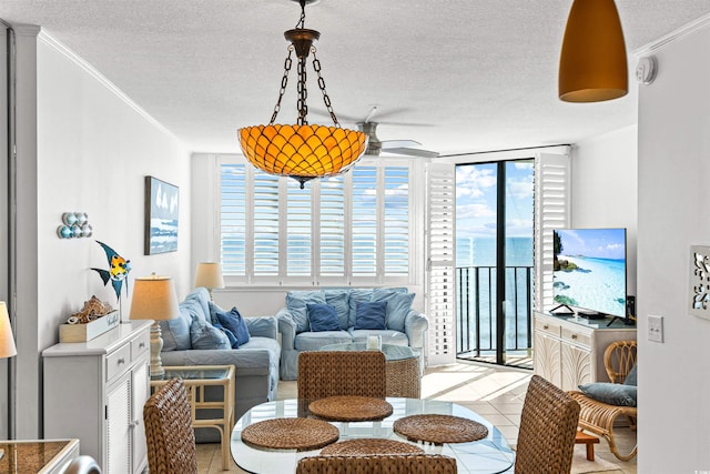 tiled living room with floor to ceiling windows, ceiling fan, a textured ceiling, and ornamental molding