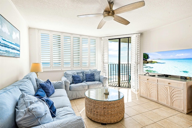 living room with ceiling fan, light tile patterned flooring, a healthy amount of sunlight, and a textured ceiling