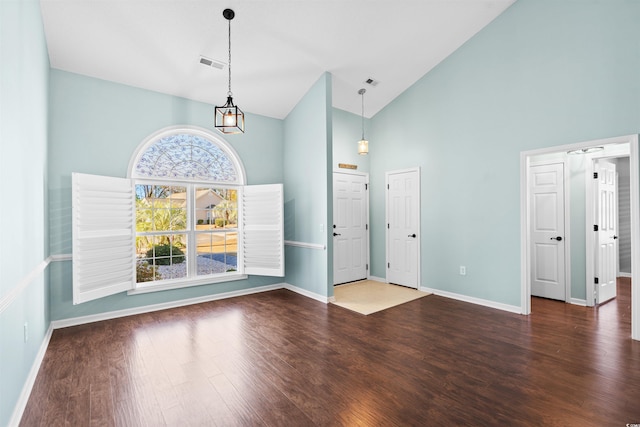 entrance foyer with dark hardwood / wood-style flooring and high vaulted ceiling