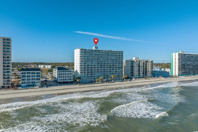 birds eye view of property with a water view and a beach view