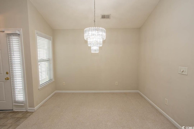 carpeted spare room featuring a chandelier, vaulted ceiling, and a healthy amount of sunlight