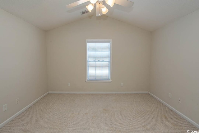 carpeted spare room with ceiling fan and vaulted ceiling